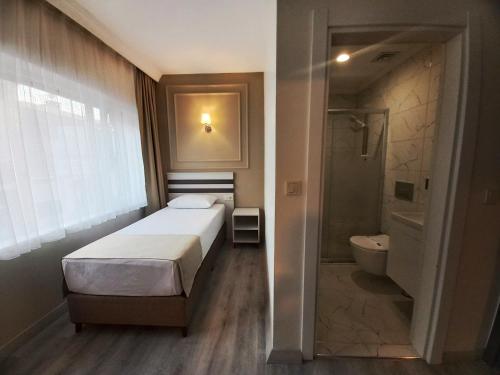 a bedroom with a bed and a shower and a toilet at GRANDAURA EDıRNE in Edirne