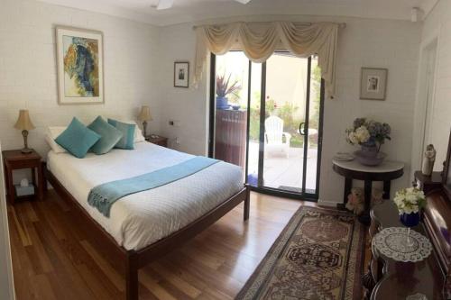a bedroom with a large bed with blue pillows at Beautiful 2Bdr House with Pool in Byron Bay