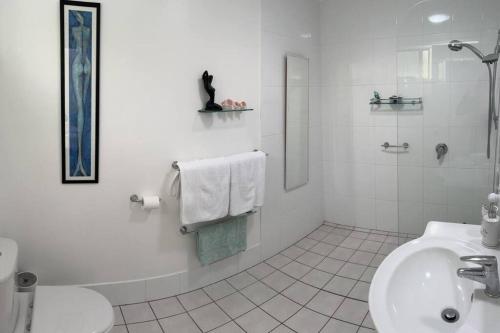 een witte badkamer met een wastafel en een toilet bij Beautiful 2Bdr House with Pool in Byron Bay