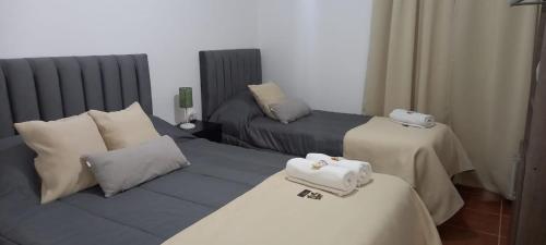 sala de estar con 2 camas y sofá en Departamentos La Perón en Villa Mercedes