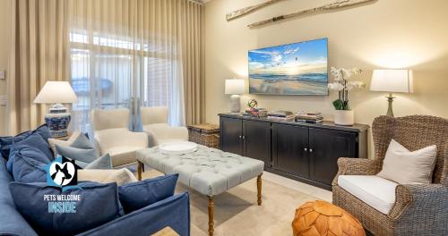 Una sala de estar con un sofá azul y sillas. en Seaspray Cottage Holiday Accommodation Victor Harbor, en Victor Harbor
