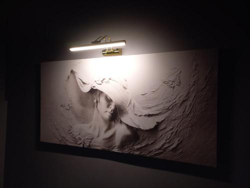a picture of a woman on a wall with a light at GRANDAURA EDıRNE in Edirne