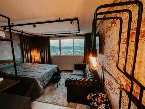 a hotel room with a bed and a window at Apartamento Luxo Executivo in Bento Gonçalves