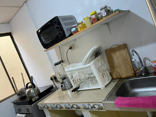 a kitchen counter with a sink and a microwave at Una Joya brillante in San Antonio