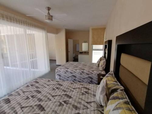 a bedroom with two beds and a large window at Marysol great views beachfront next to nomads d3 in Isla Mujeres