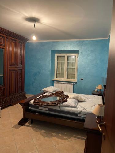 una camera con un grande letto con una parete blu di Appartamento Marchesini a Ceccano