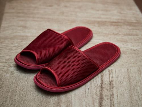 a pair of red slippers sitting on the floor at Grand Cabin Hotel Naha Oroku for Men / Vacation STAY 62323 in Naha