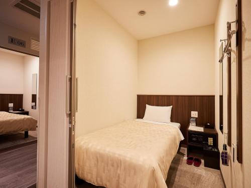 um pequeno quarto com uma cama e um quarto com em Grand Cabin Hotel Naha Oroku for Women / Vacation STAY 62324 em Naha