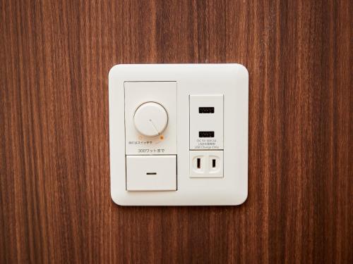 una toma de corriente eléctrica en una pared de madera en Grand Cabin Hotel Naha Oroku for Women / Vacation STAY 62324 en Naha
