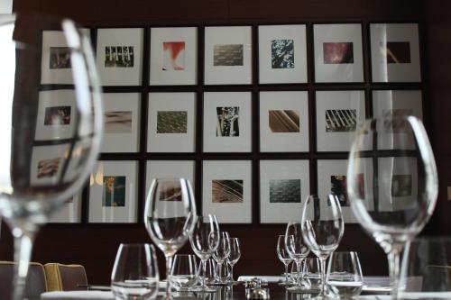 a table with wine glasses in front of a wall with pictures at Pullman Sydney Olympic Park in Sydney