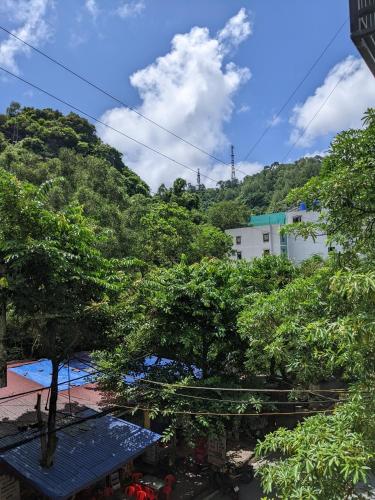 a view of trees and a building with a blue table at Tung Quang Hotel in Cat Ba