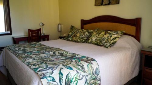 1 dormitorio con 1 cama grande y edredón blanco en Hotel Ontiveros en San Fernando
