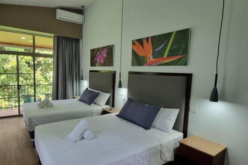 a hotel room with two beds and a window at Villas Töcu-Casa Perezoso in Fortuna
