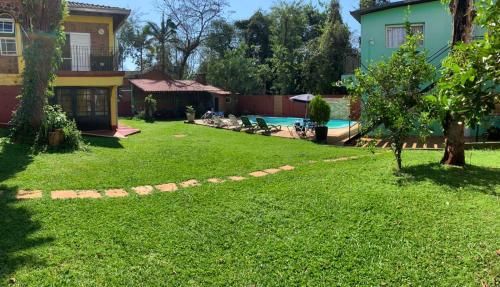 a yard with a swimming pool and a house at Apart JM in Puerto Iguazú