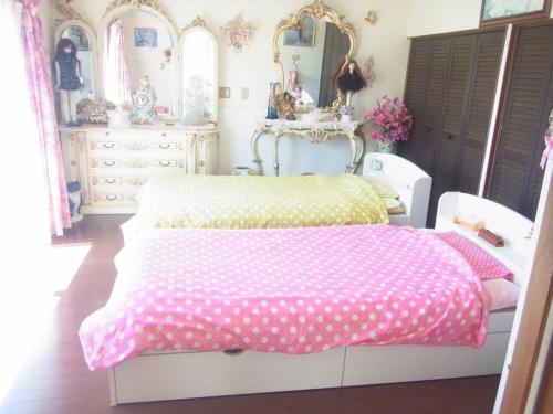1 dormitorio con 1 cama blanca con sábanas de lunares en HealingDragon 　Sunrise house Shirahama, en Shimoda