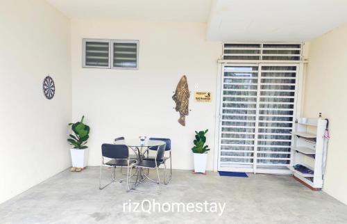 a dining room with a table and chairs and a window at RizQ Homestay Tg Malim in Kerling