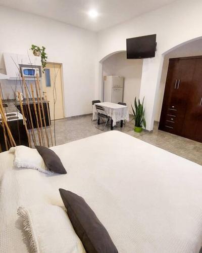 Cama blanca grande en habitación con mesa en Alvarado - sereno descanso en Salta