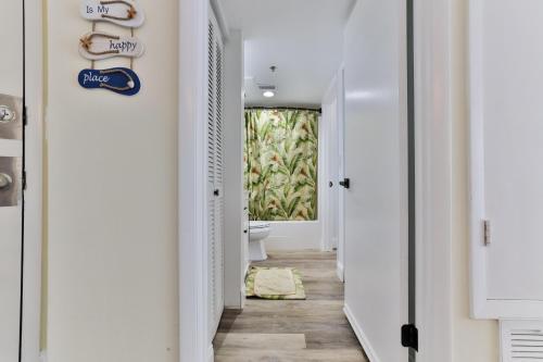 a corridor of a bathroom with a toilet and a window at 1 Bedroom -1 Bath With Ocean Views At Ocean Trillium 302 in New Smyrna Beach