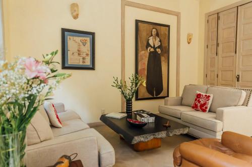 a living room with couches and a painting of a woman at Maison du comte in Mexico City