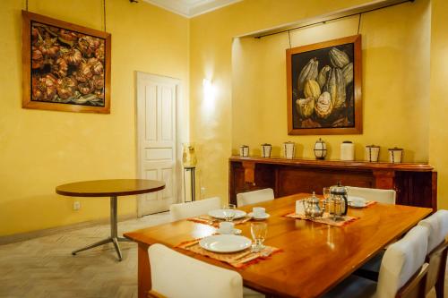 uma sala de jantar com uma mesa de madeira com cadeiras brancas em Maison du comte em Cidade do México