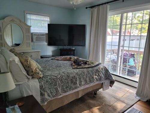 a bedroom with a bed and a large window at Saybrook Manor Beach House in Old Saybrook