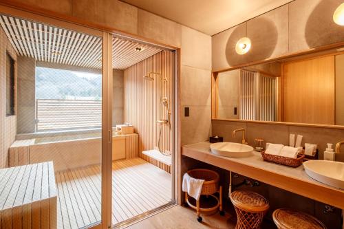 a bathroom with a shower and a sink and a tub at Kifuno Sato in Mimasaka