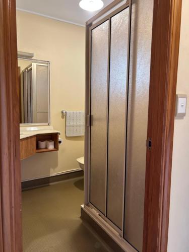 a bathroom with a shower and a toilet and a mirror at Masterton Motor Lodge in Masterton