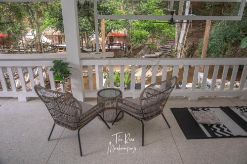 two chairs and a table on a porch at เดอะริเวอร์ แม่กำปอง The River Maekampong Chiang Mai in Ban Pok Nai