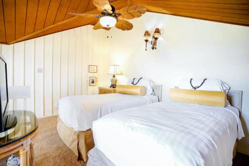 um quarto com 2 camas e uma ventoinha de tecto em Manualoha in PoiPu em Koloa