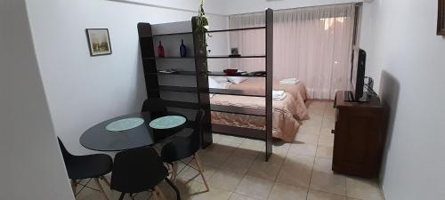 Habitación pequeña con cama, mesa y sillas en Súper Luminoso en Caballito en Buenos Aires