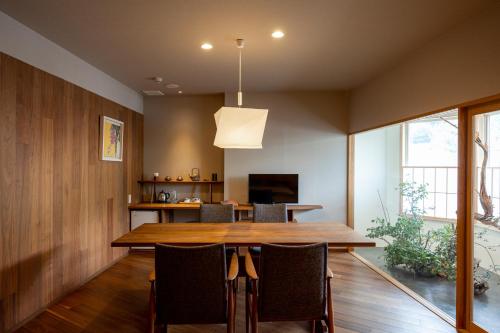 a dining room with a wooden table and chairs at Kifuno Sato in Mimasaka