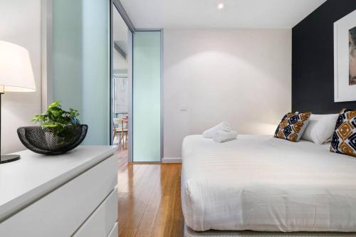a bedroom with a white bed and blue walls at 'Collins Central' Sleek Light-filled Pad in the CBD in Melbourne