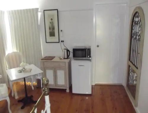 a kitchen with a white refrigerator and a microwave at R&R Blue Diamond Luxury Studio Maryborough, Vic in Maryborough