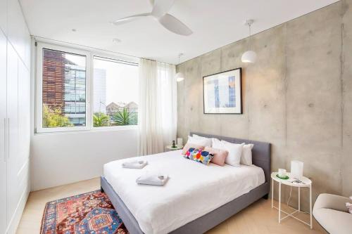 a bedroom with a large white bed and a window at 'The Fern' Split-Level Retreat with Lush Courtyard in Sydney