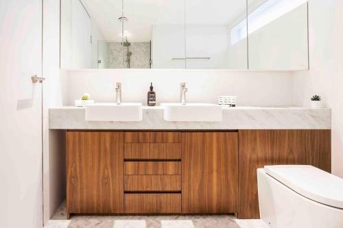 een badkamer met 2 wastafels en een toilet bij Sustainable Luxury in Australia's 1st Passive Apartment in Sydney