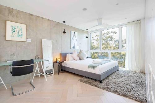 a bedroom with a bed and a desk and a window at Sustainable Luxury in Australia's 1st Passive Apartment in Sydney