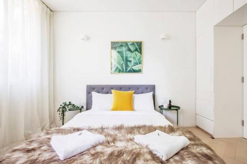 1 dormitorio blanco con 1 cama grande con manta peluda en 'Sustainable Luxury' Australia's first Passive Apt, en Sídney
