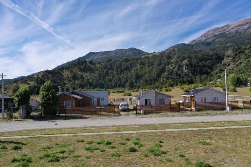 une rangée de maisons devant une montagne dans l'établissement Cabaña Puerto Sánchez RYS Patagonia A, 