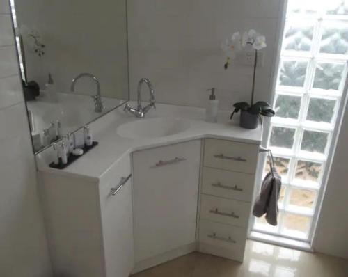 a white bathroom with a sink and a mirror at R&R Blue Diamond Luxury Studio Maryborough, Vic in Maryborough