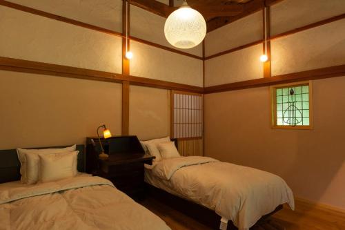 安來市的住宿－Ryokuinsansou-bettei - Vacation STAY 48641v，客房设有两张床、一台电视和一扇窗户。