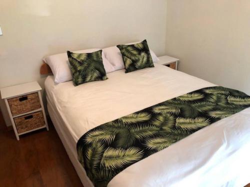 een bed met twee kussens erop bij Are Ara - House of Pineapple in Titikaweka