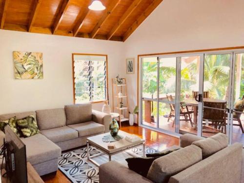 een woonkamer met een bank en een tafel bij Are Ara - House of Pineapple in Titikaweka