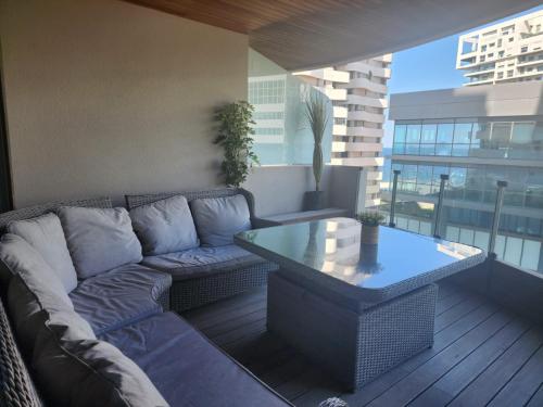 uma sala de estar com um sofá e uma mesa na varanda em Appartement de luxe Marina Casablanca em Casablanca