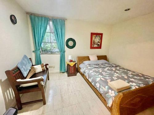 a bedroom with a bed and a chair and a window at Flower House Villa in Bogor
