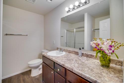 a bathroom with a sink and a toilet and a mirror at Charming Arkansas Getaway - Walk to Downtown! in Fort Smith