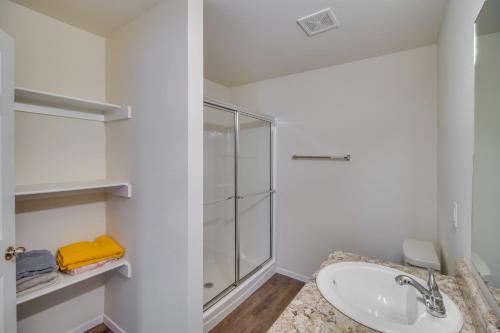 a white bathroom with a sink and a shower at Charming Arkansas Getaway - Walk to Downtown! in Fort Smith
