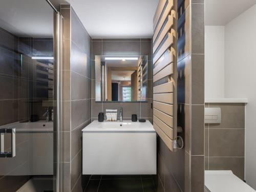 une salle de bain avec un lavabo et un miroir dans l'établissement Appartement avec piscine, salle de sport et parking couvert - FR-1-569-105, à Megève