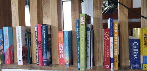 a row of books sitting on a shelf at The Beach House at Dipnay San Fernando, El Nido in El Nido