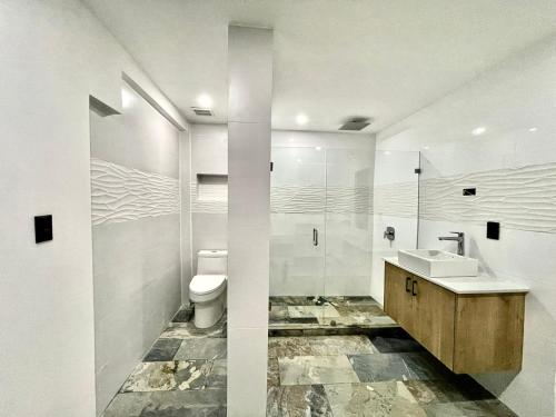 マヌエル・アントニオにあるPura Natura Lodge Manuel Antonioの白いバスルーム(洗面台、トイレ付)
