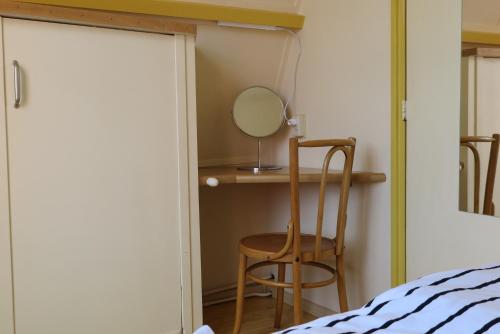 a bedroom with a mirror and a chair next to a bed at Zierikzee Appartement ZZ 41 at the Waterfront in Zierikzee